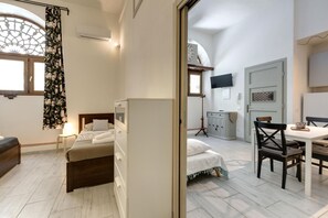 A bedroom with a bed, bedside table, and a window with a curtain. - Santa Maria 3B in Firenze (Florence)