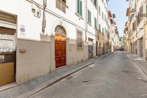 A narrow street lined with buildings, some with closed shutters, and a clear sky above. - Campuccio 42 in Firenze (Florence)