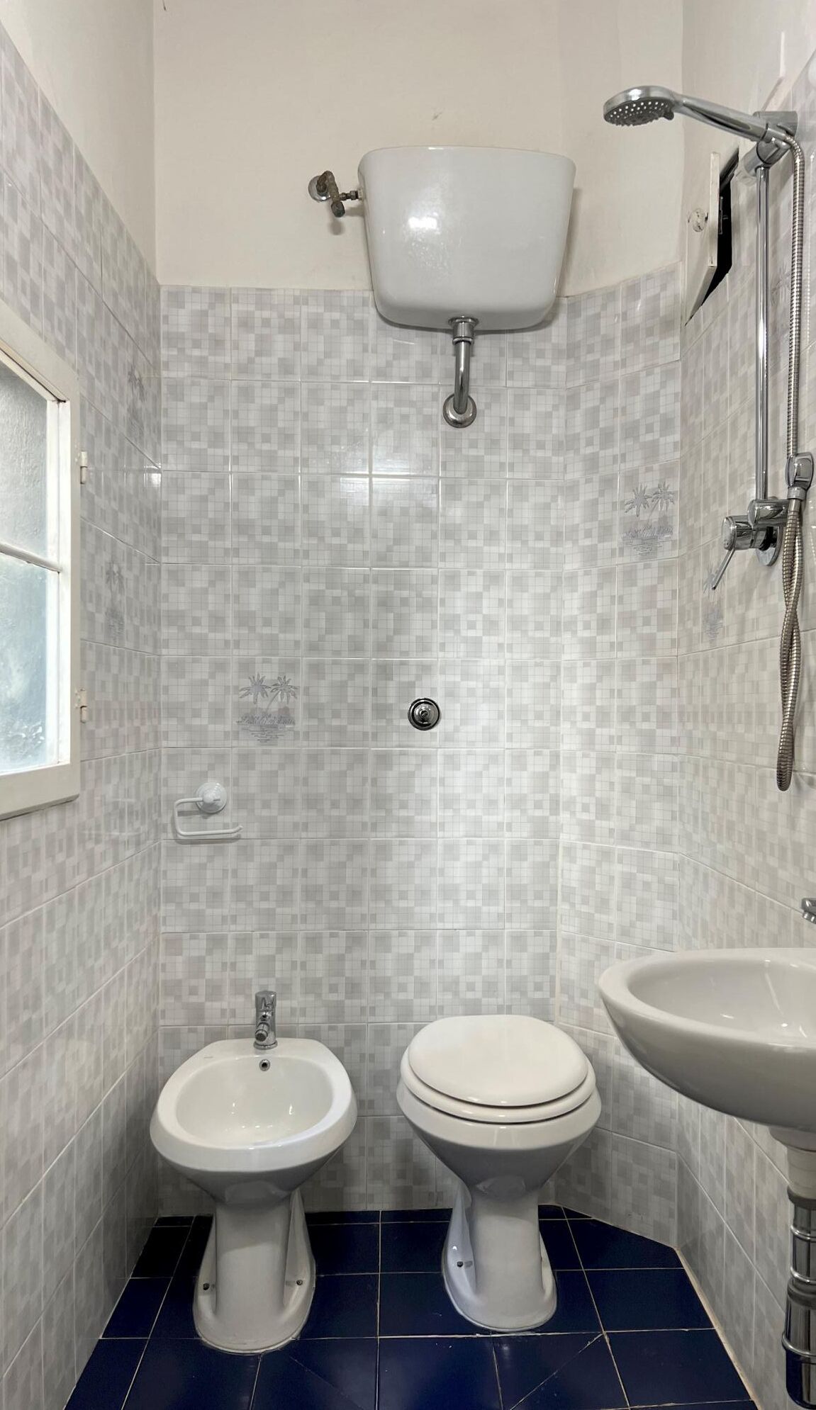 A bathroom with a toilet, bidet, and sink.