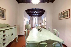 Un comedor con una larga mesa, sillas, un aparador y cuadros en las paredes.