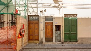 A narrow street with three wooden doors, numbered 10, 12, and 8, and a speed limit sign of 30. - Santa Maria 10 in Firenze (Florence)