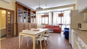 A compact living space with a dining area, a sofa, and a kitchenette. - Ponte Vecchio 4 Bedrooms (Florence)