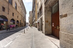 A narrow street lined with historic buildings, some with storefronts and signage. - Ponte Vecchio 4 Bedrooms (Florence)