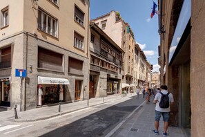 A narrow street lined with multi-story buildings, some with balconies and shops on the ground floor. - Ponte Vecchio 4 Bedrooms (Florence)