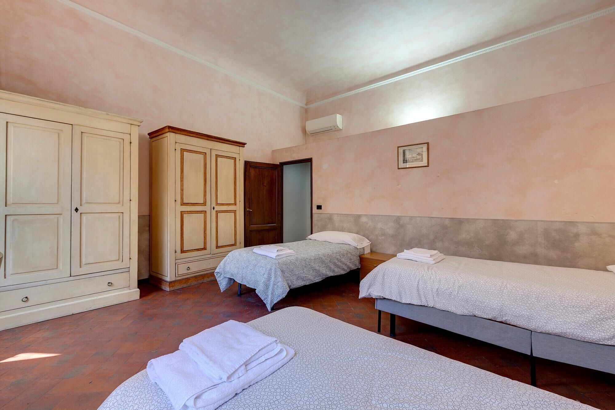 A room with two single beds, a wardrobe, and a door.