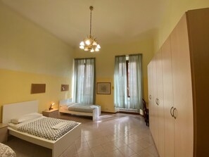 A bedroom with a bed, bedside table, lamp, wardrobe, and a chandelier. - Ghibellina 90 in Firenze (Florence)