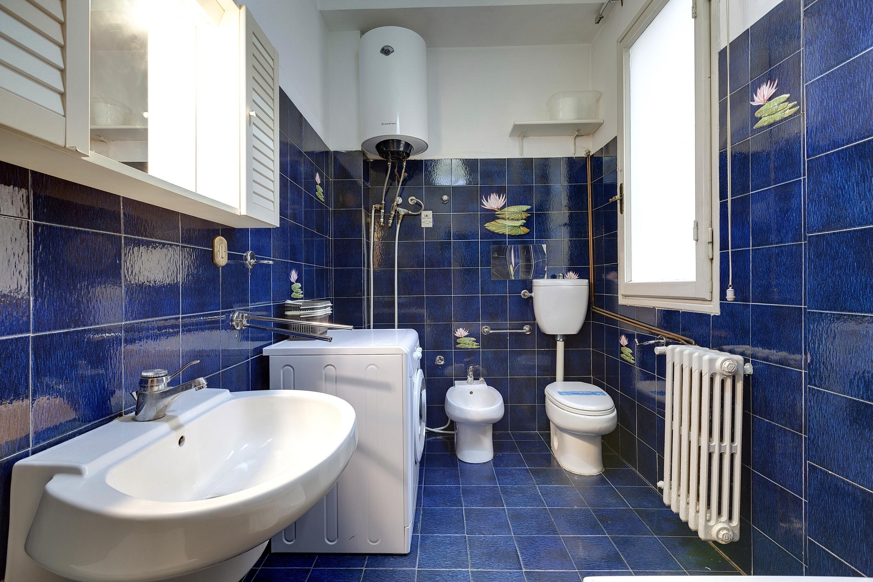 Une salle de bain équipée d’un lavabo, de toilettes, d’un bidet et d’un radiateur.