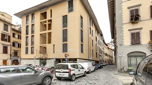 A narrow street lined with parked cars and buildings with multiple windows and balconies. - Malenchini 6 in Firenze (Florence)