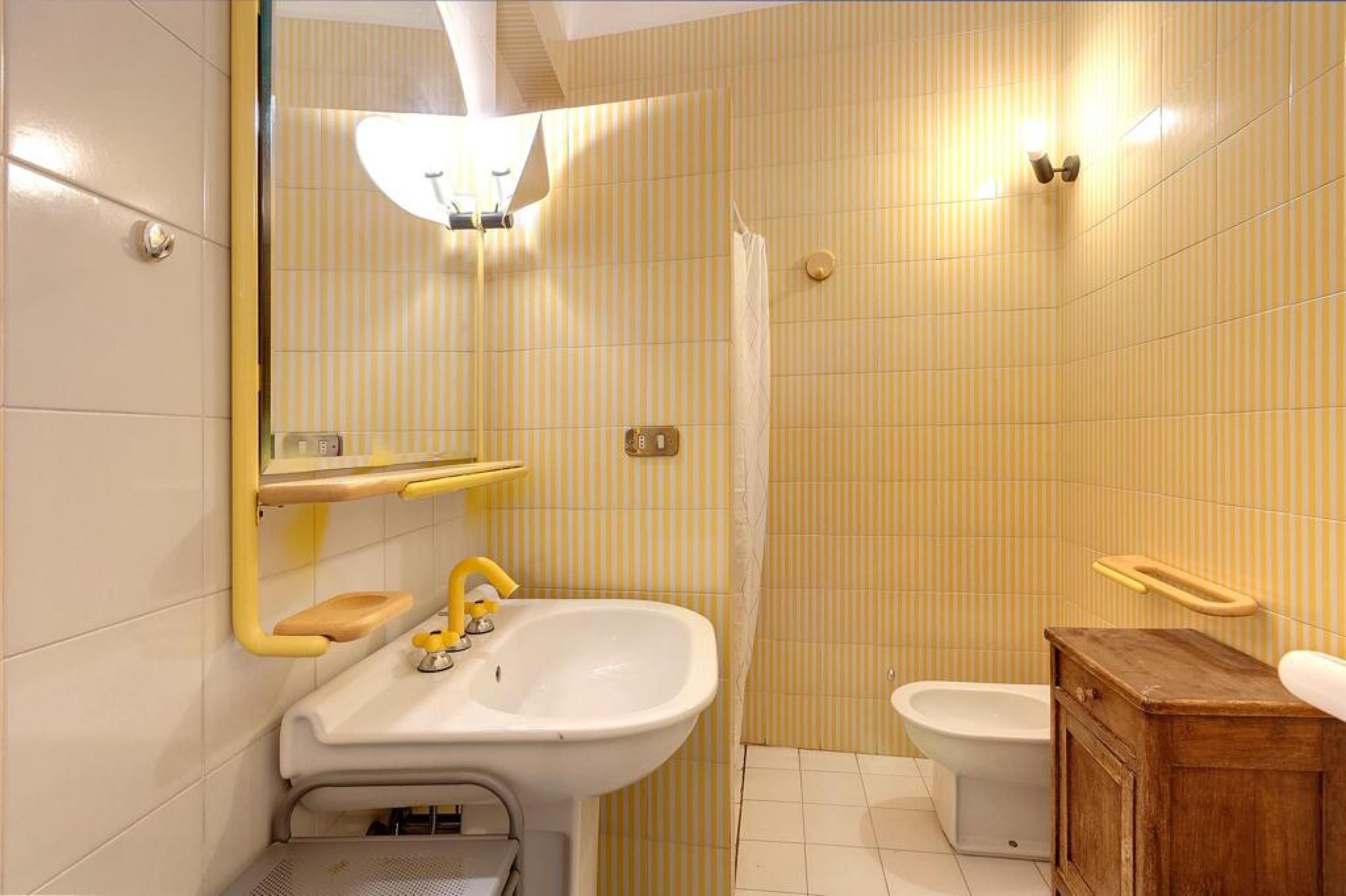 Un baño con lavabo, espejo e inodoro.