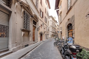 A narrow street lined with historic buildings, featuring a row of parked scooters and bicycles. - Parione 12 in Firenze (Florence)