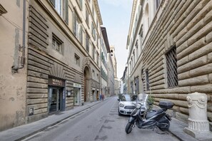 A narrow street with historic buildings, a parked scooter, and a car. - Ghibellina 123 in Firenze (Florence)