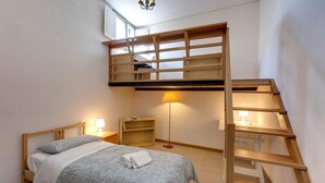 A bedroom with a bunk bed, a desk, a chair, a lamp, and a ladder. - Benedetta 8 in Firenze (Florence)