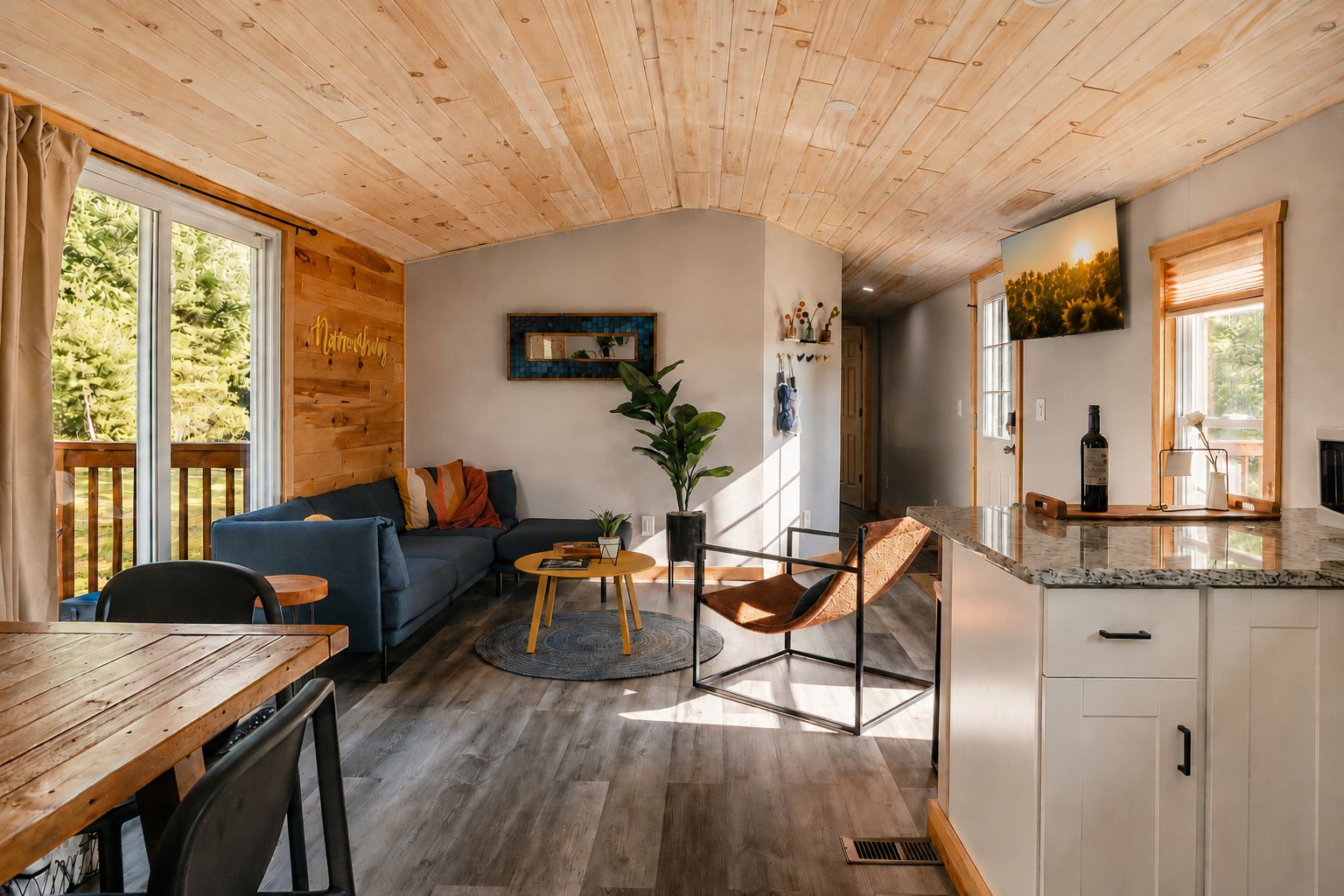 A modern interior with a wooden ceiling, a sofa, a dining table, and a kitchen area.