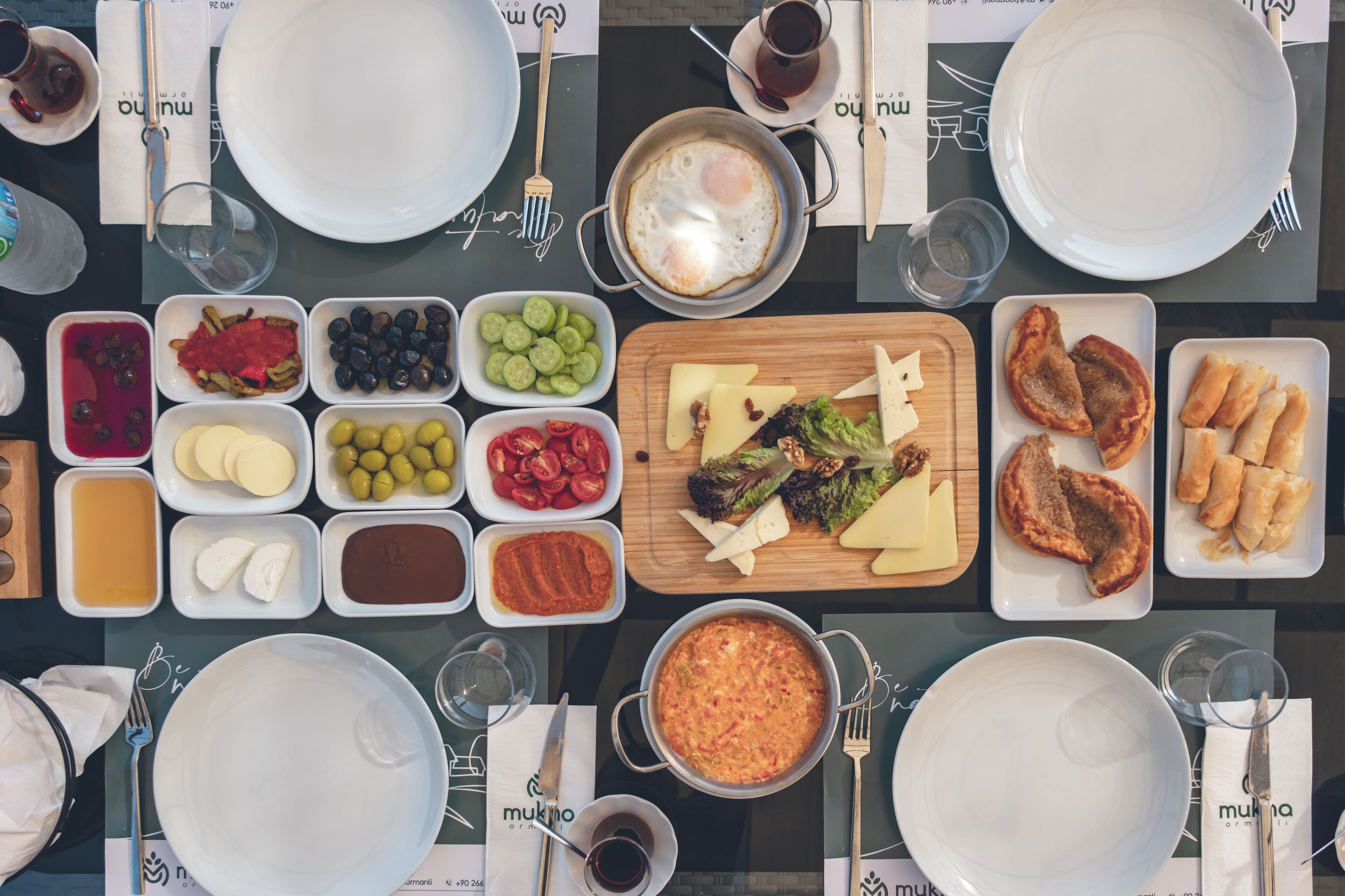 A table set for breakfast with various dishes, including eggs, cheese, and bread.