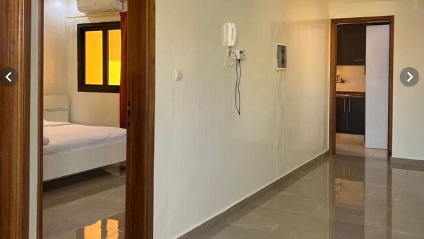 Passadís d'hotel amb un llit, un telèfon i una dutxa.