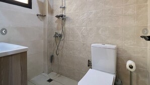 Un bany amb vàter, dutxa i rentapel.