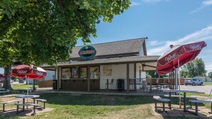 Un área de asientos al aire libre con mesas y sombrillas en un restaurante llamado Alexander's.