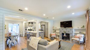 A spacious living room with a grey sofa, wooden dining table, and a fireplace. - ‘Pecan Blue’ Frisco Hub: Dtwn, Dining & Stadiums! (Frisco)