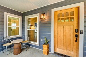A residential entryway with a wooden door, two windows, a potted plant, and a small table with chairs. - ‘Pecan Blue’ Frisco Hub: Dtwn, Dining & Stadiums! (Frisco)