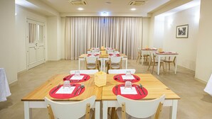 A conference room with multiple tables set for meetings, equipped with chairs, tables, and a projector screen. - Verdello Home Savoca (Savoca)