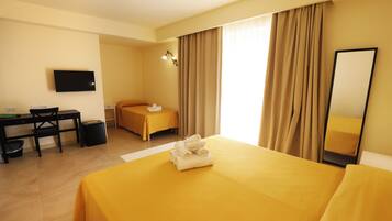 Ein Hotelzimmer mit Bett, Schreibtisch, Stuhl, Fernseher und Bad.