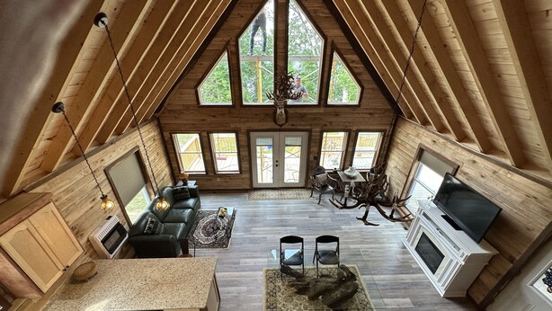 Un loft espacioso con techos altos, ventanas amplias, chimenea y comedor.