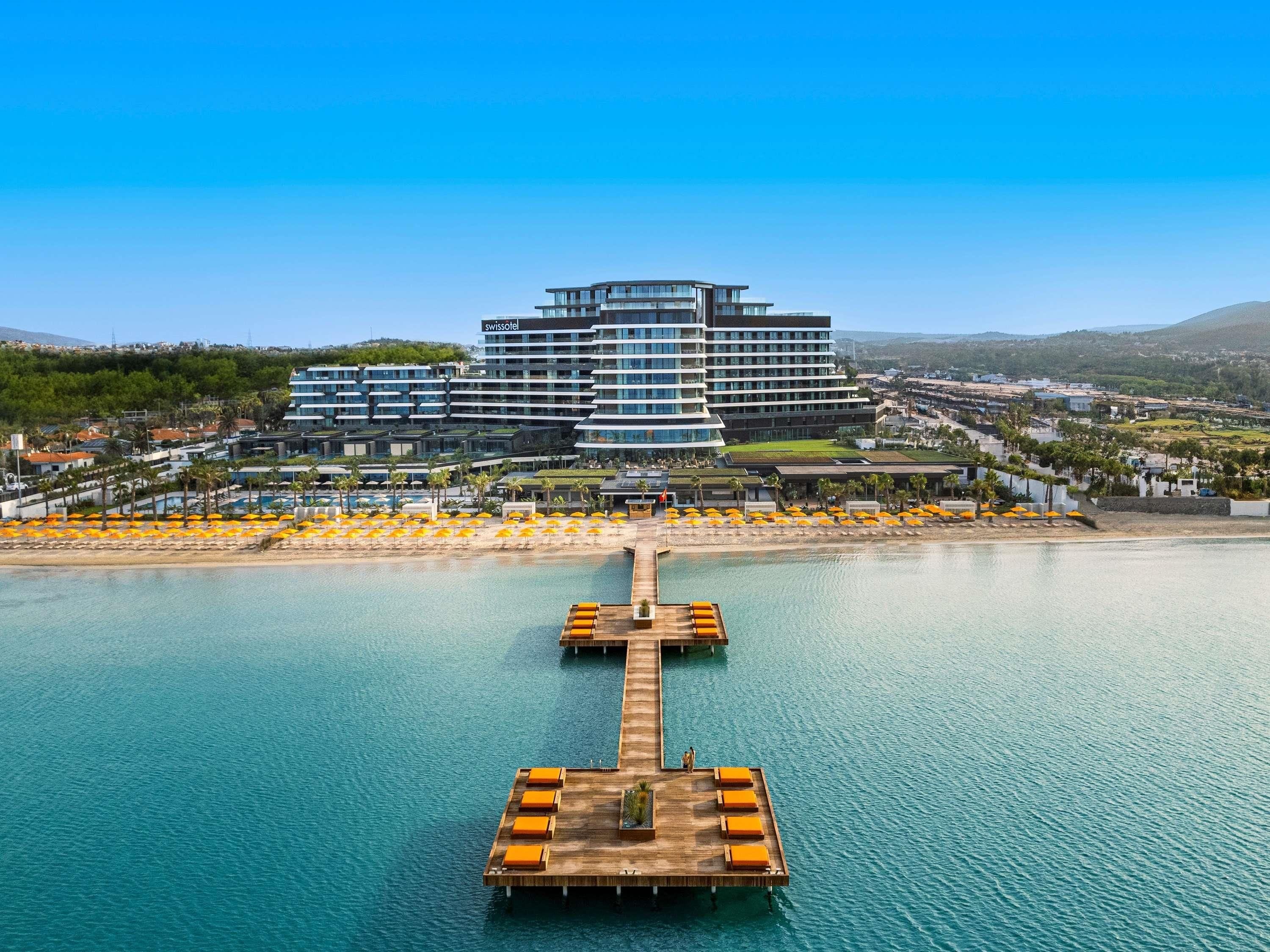 Un hotel moderno con piscina, muelle y zona de playa.