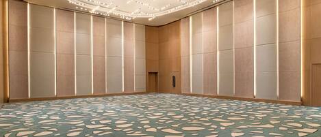 A conference room with a patterned carpet, recessed lighting, and a modern ceiling design.