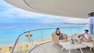 Un balcón moderno con vistas despejadas al mar y a la costa distante.