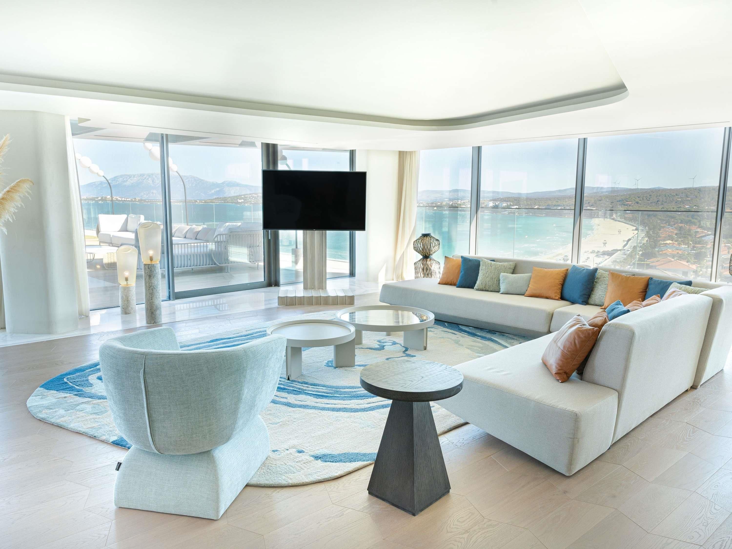 A modern living room with a large sofa, a coffee table, and a TV.