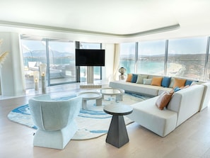 Una sala de estar moderna con un sofá grande, una mesa de centro y un televisor.