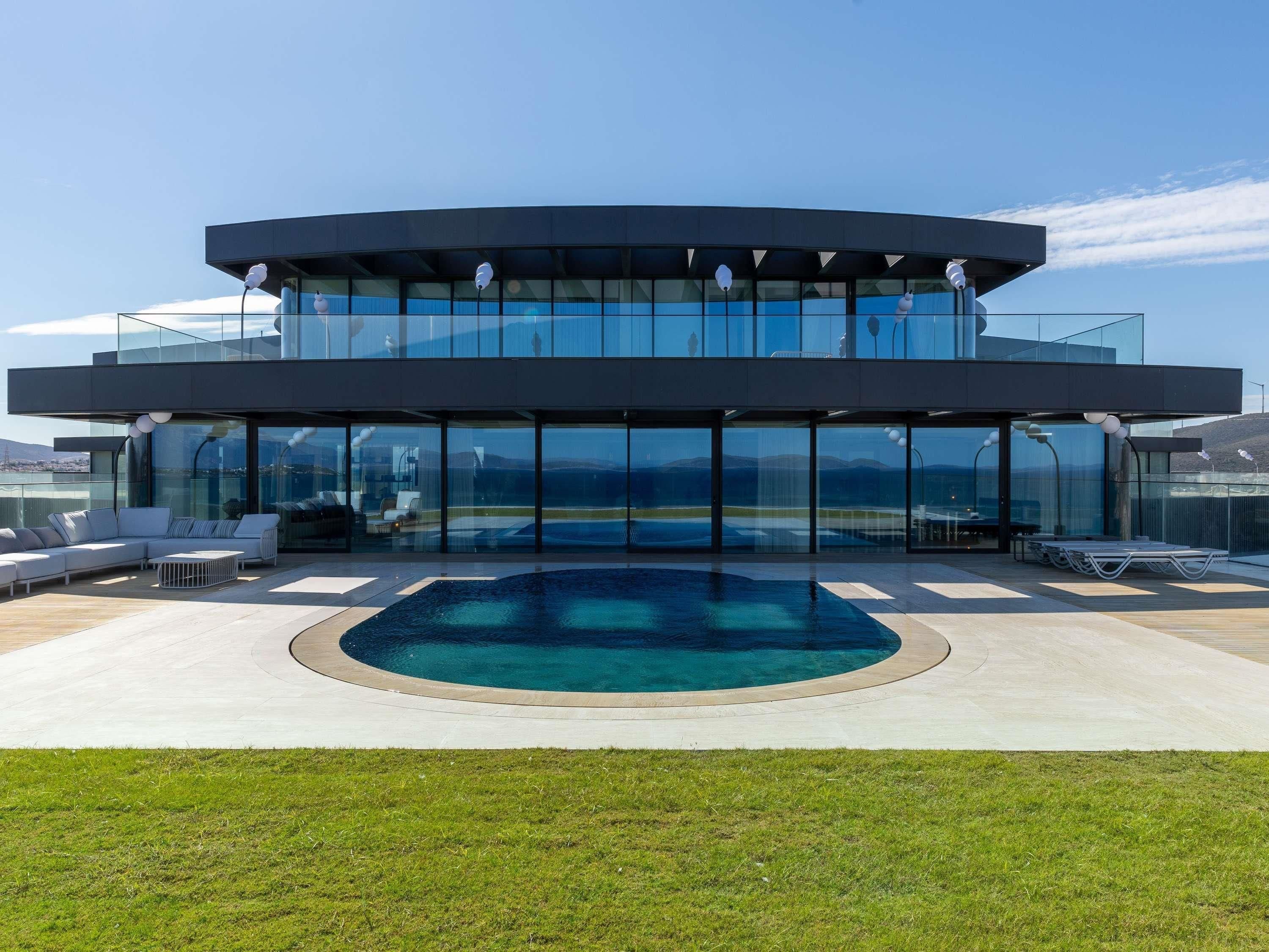 Ein modernes Gebäude mit Pool, Glasfassaden und Außenbereich.