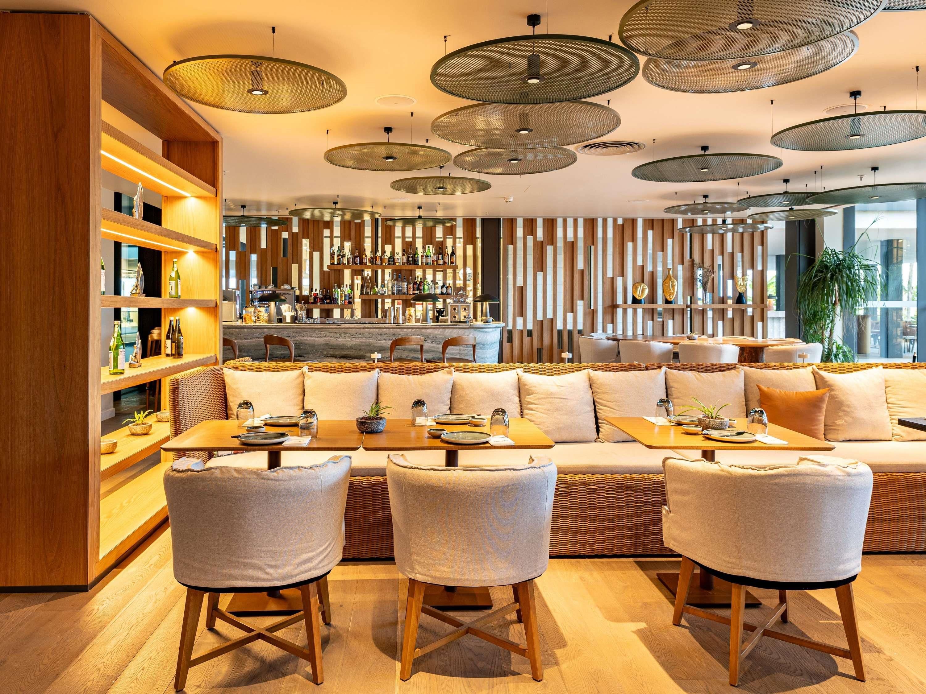 A modern interior with a bar area, seating, and a patterned wall.