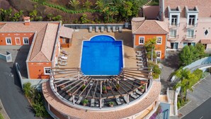 A circular building with a central pool, surrounded by terraces and balconies. - Villa Gasparini (Funchal)