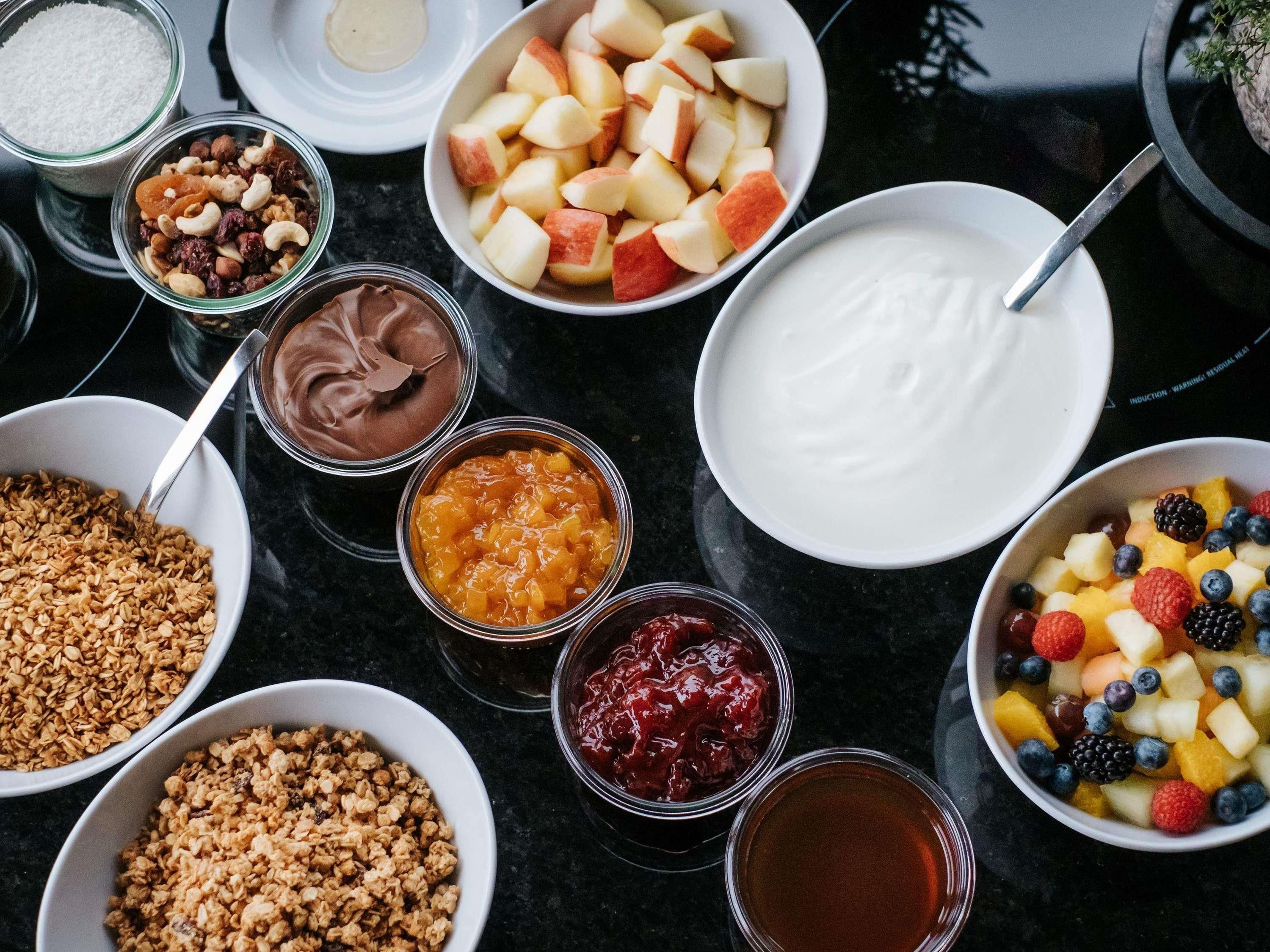 A variety of food items including fruits, nuts, and yogurt on a table.