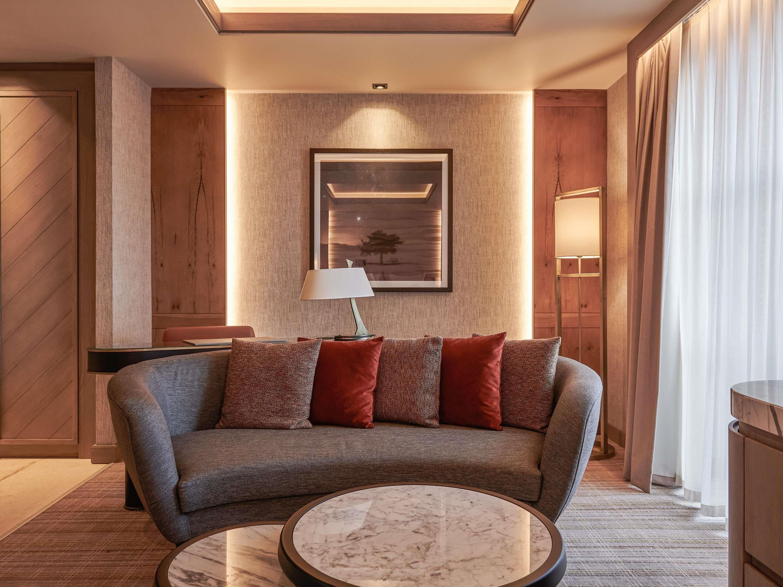 Un salon moderne avec un canapé, une table basse ronde, une lampe et un tableau encadré au mur.