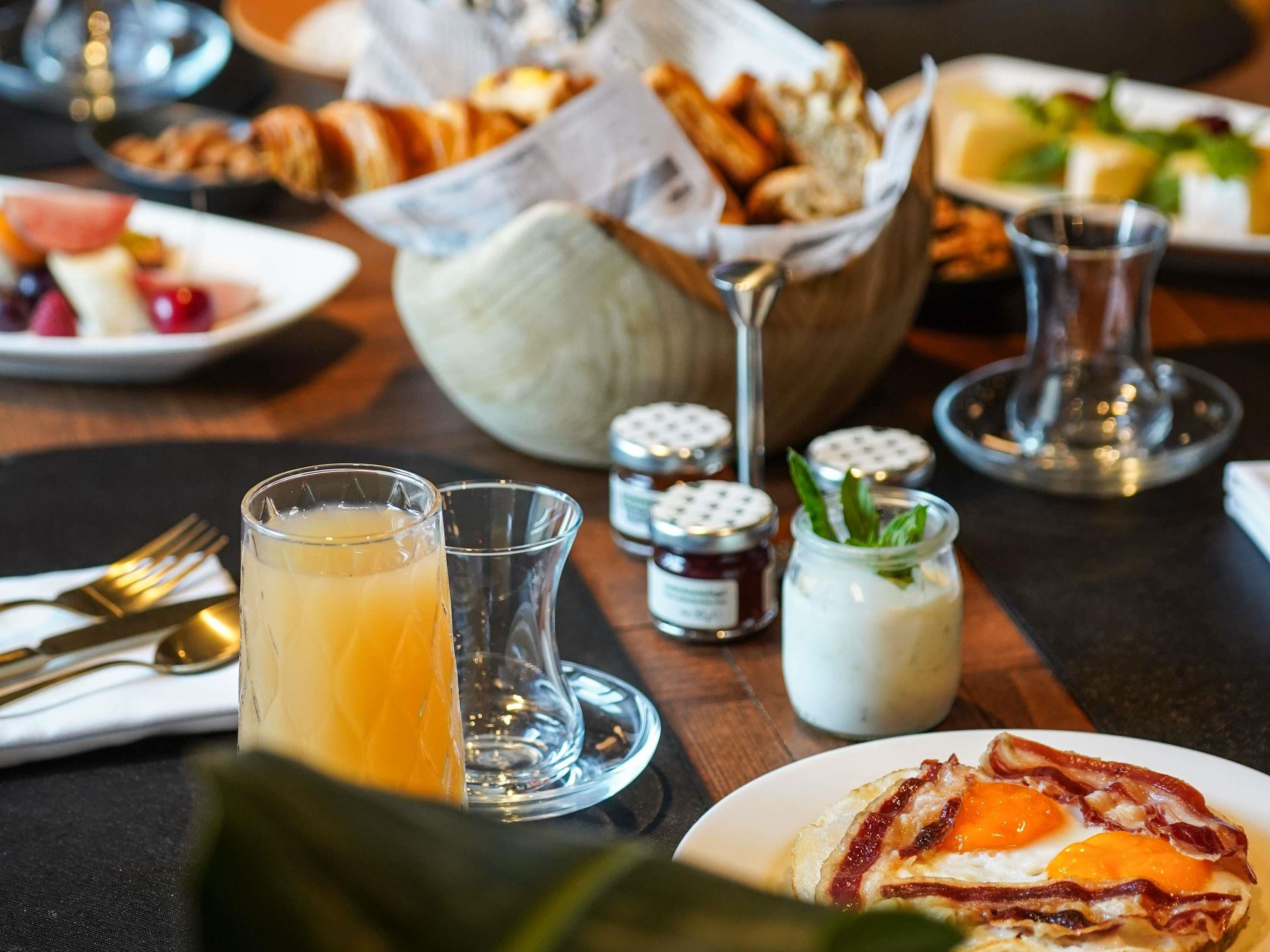 A breakfast setting with a plate of eggs, toast, and a glass of orange juice.