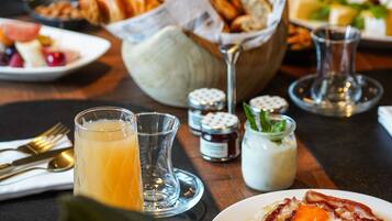 A breakfast setting with a plate of eggs, toast, and a glass of orange juice.