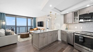 Una cocina moderna con una isla grande, electrodomésticos de acero inoxidable y vistas al océano.