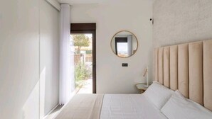 A bedroom with a large bed, a round mirror, and a view of the outdoors. - Villa with sea view (Finestrat)