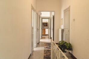 Stylish hallway with a clean, minimalist aesthetic, featuring a radiator and a potted plant.