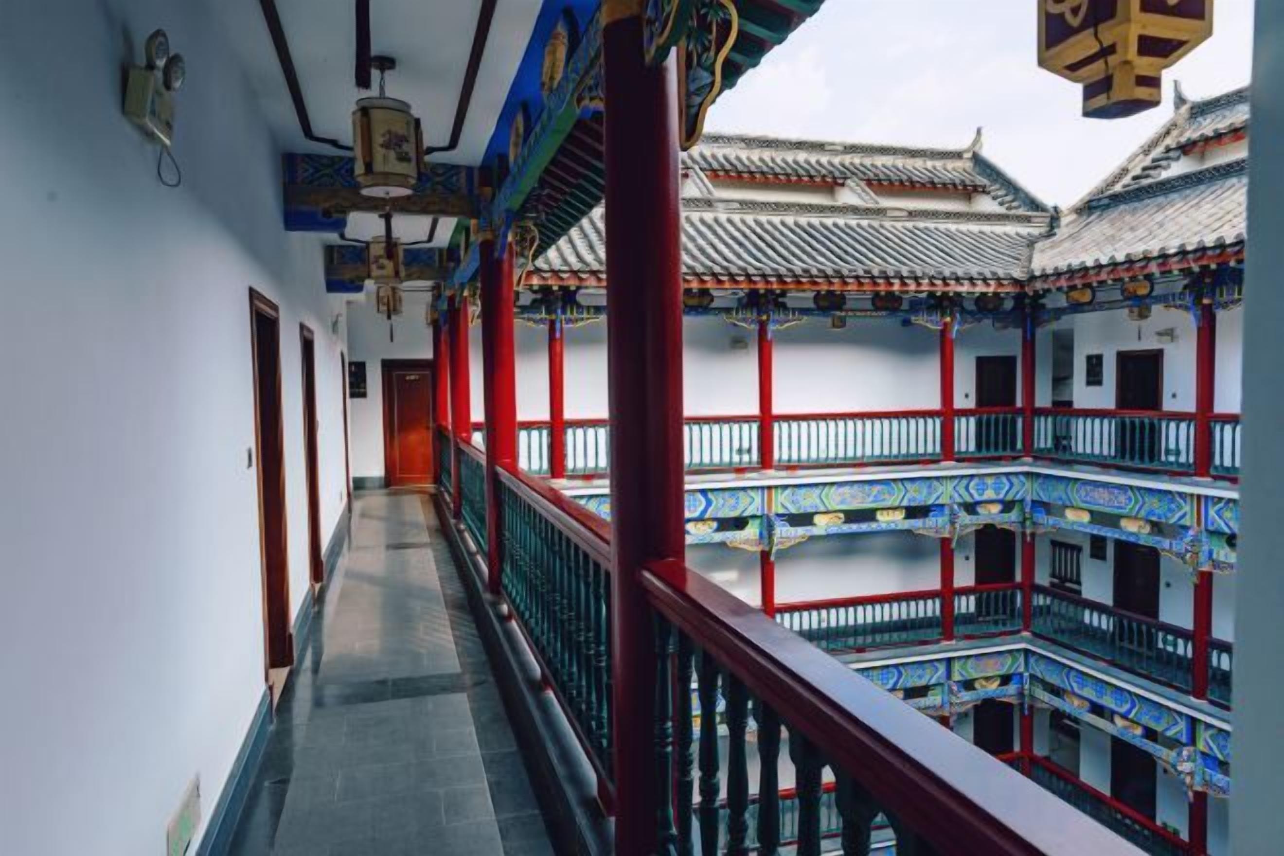 A corridor with traditional architecture, including tiled roofs and red columns.