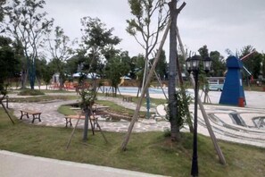 A park with playground equipment, picnic tables, and a windmill. - Taohuayuan Liu Contract Chun Inn (Taoyuan)