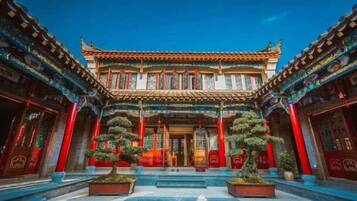 A traditional building with a symmetrical facade, multiple windows, and a central entrance.