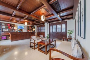 A traditional interior with wooden furniture, a reception desk, and a large window.
