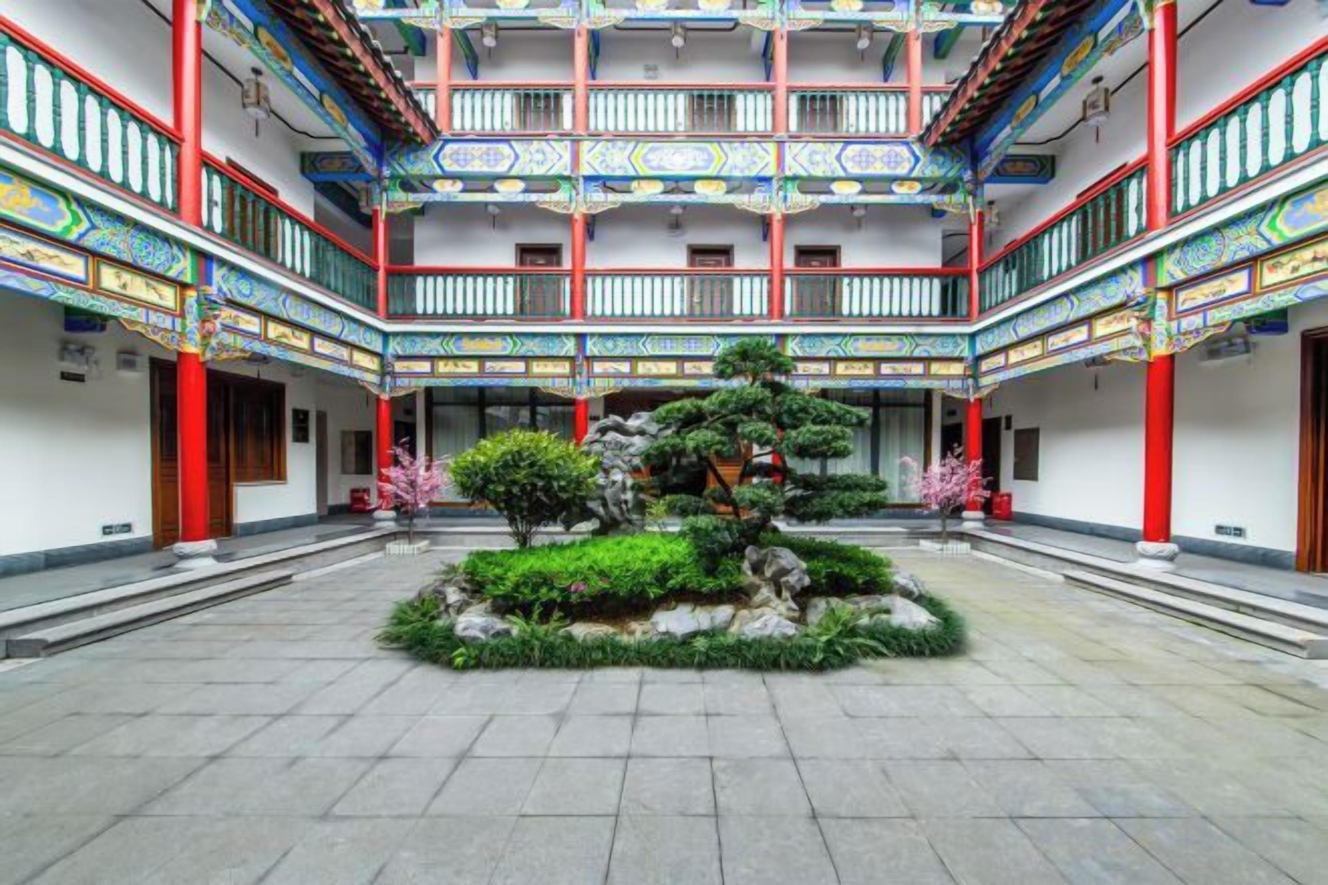 A courtyard with a central garden, traditional architecture, and multiple balconies.