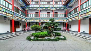 A courtyard with a central garden, traditional architecture, and multiple balconies.