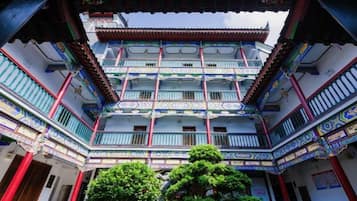 A traditional multi-story building with ornate balconies and a central courtyard.