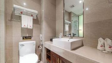 Un baño moderno con inodoro, lavamanos y espejo.