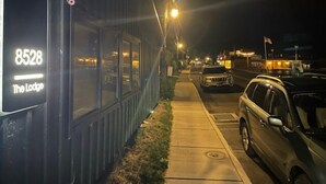 A building with a sign reading "8528 The Lodge" at night.